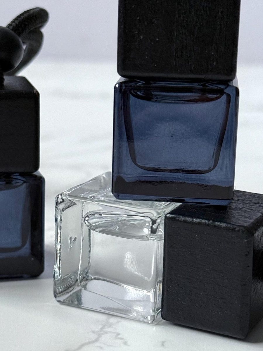 Close detail of the clear glass vessel and blackened wood cap