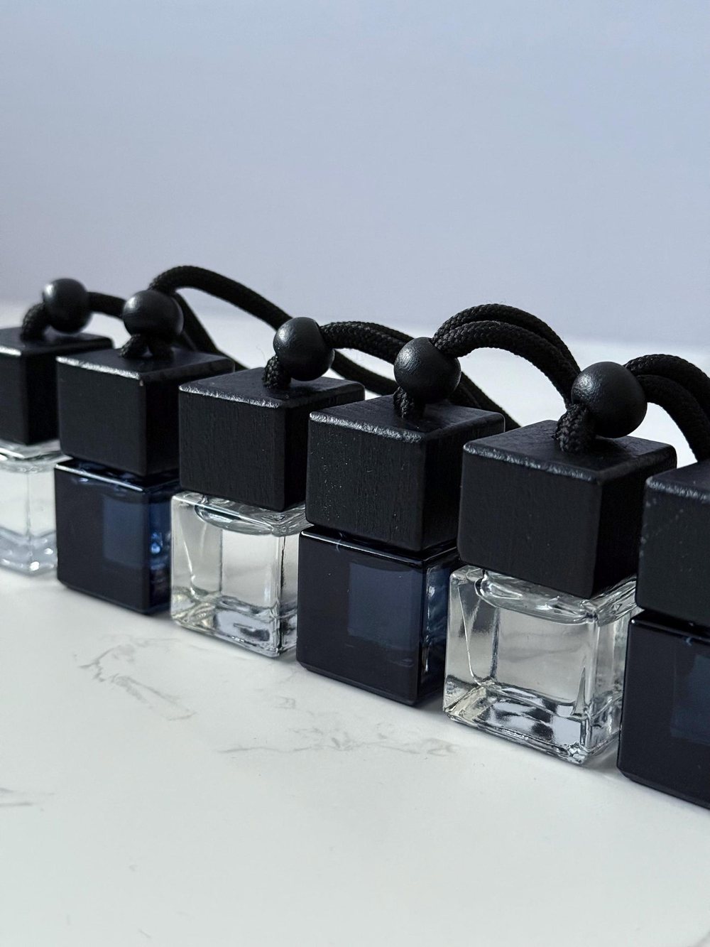 Clear and smoked glass diffusers lined up on marble