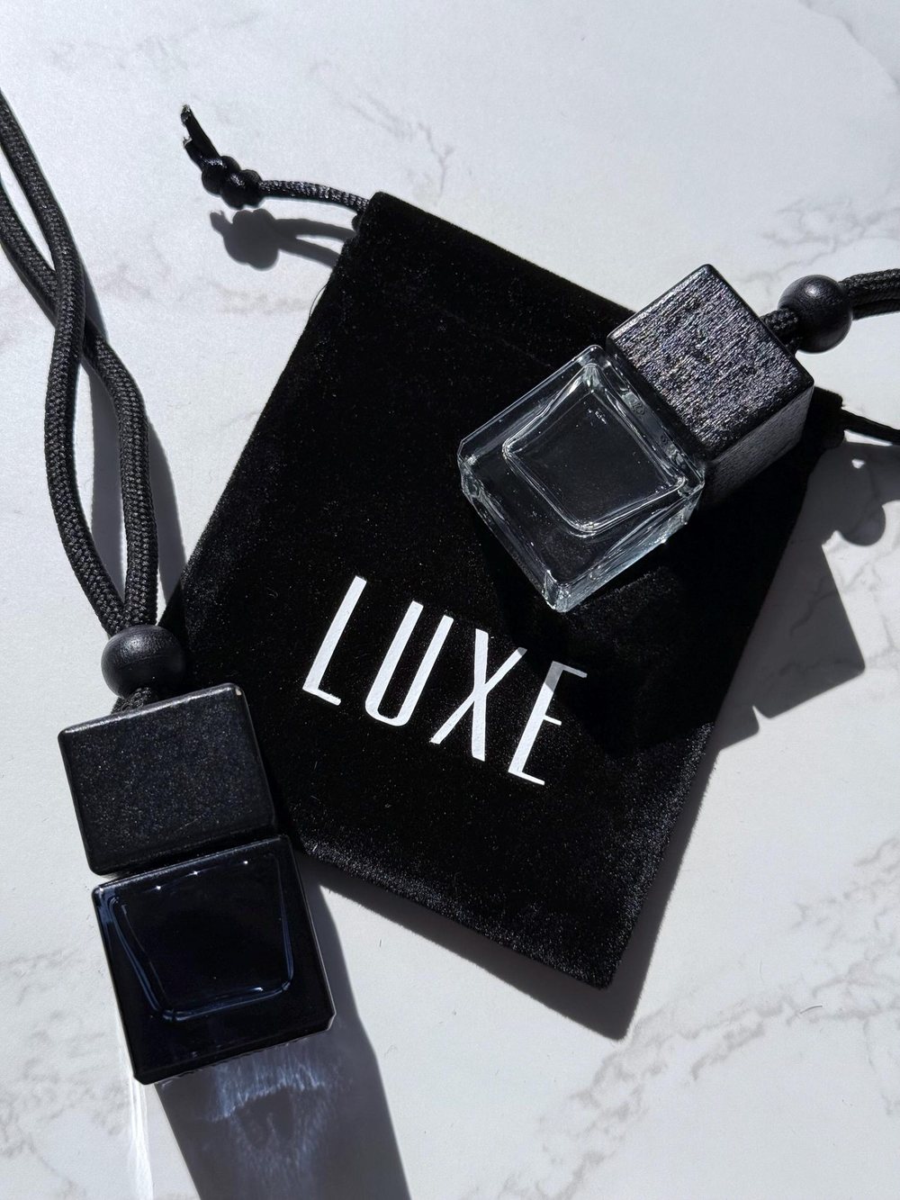 A diffuser and its velvet pouch on marble